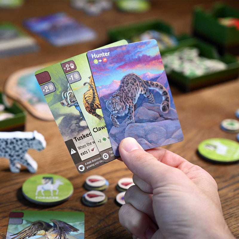 Hand holding a card with a leopard illustration in a board game setting