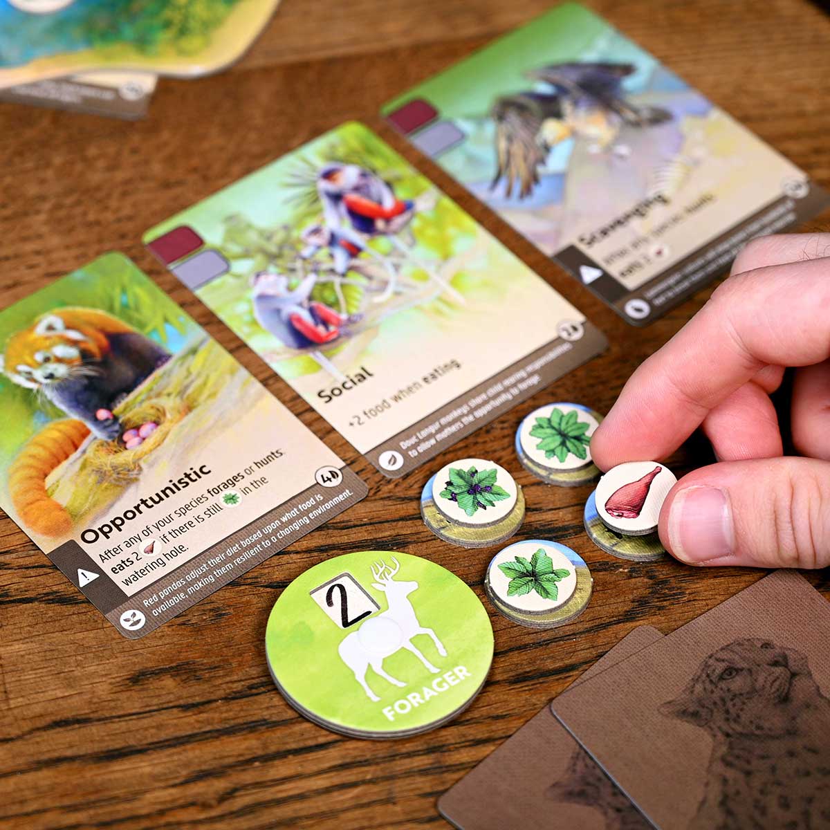 Board game with cards and player tokens on a wooden surface